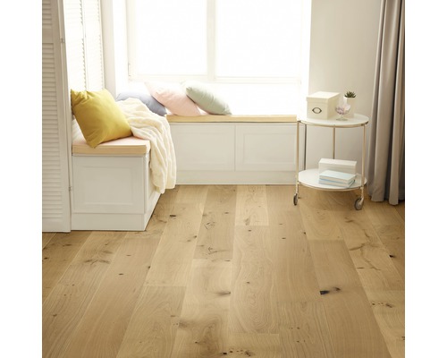 Lichte kamer met houten vloer, vensterbank met kussens en bijzettafel