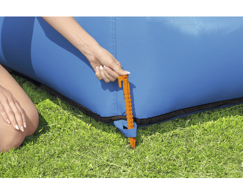 Detailweergave van een grondpen om een blauwe opblaasbare bank in de tuin te bevestigen.