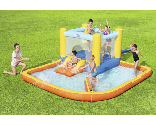 Opblaasbaar springkasteel met waterglijbaan en peuterbad in de tuin met spelende kinderen