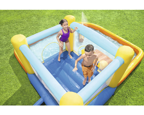 Opblaasbaar springkasteel met zwembad en twee kinderen in de tuin.