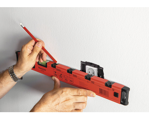 Een waterpas wordt gebruikt om een markering te maken op een muur met een stopcontact.