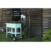 Verhoogde plantenbak op wielen in de tuin