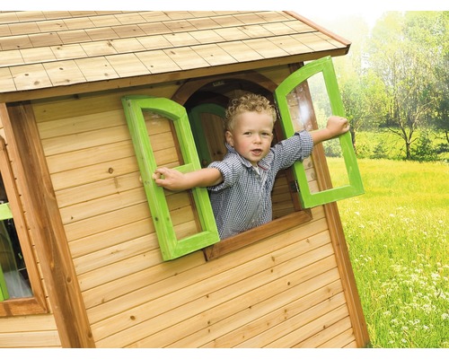 Kind kijkt uit raam van houten speelhuis