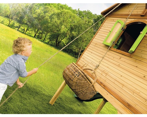 Kind speelt met een boomhut met korbellift in de tuin.