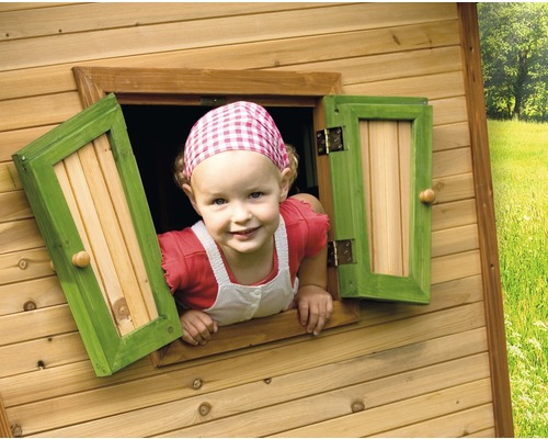 Kind kijkt uit het raam van een houten speelhuis
