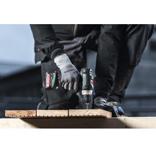Iemand boort met een Metabo accuschroefboormachine in een houten plank.