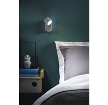 Wandlamp naast bed met nachtkastje en decoratie