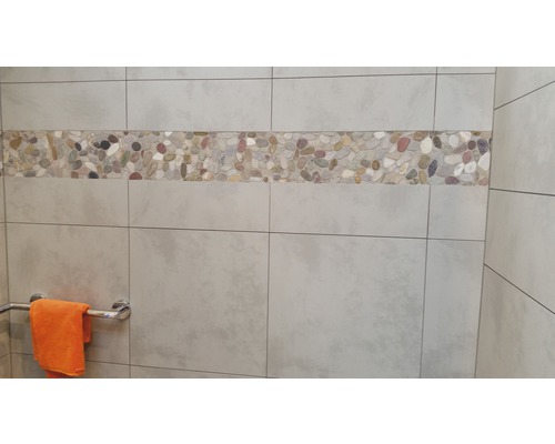 Wandtegels met kiezelsteenrand in een badkamer.