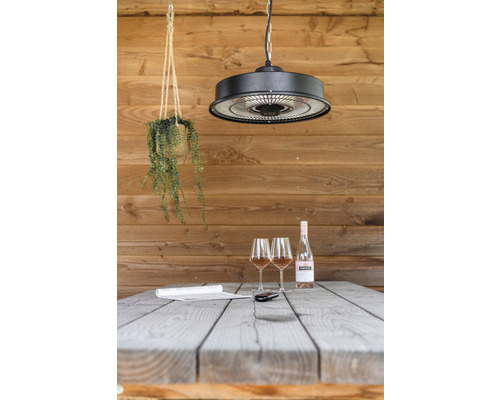 Scene met terrasverwarmer, tafel, twee glazen en een fles