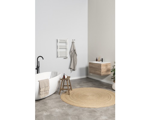 Lichte badkamer met vrijstaand bad, wastafelonderkast, handdoekradiator en rond vloerkleed