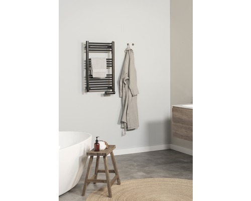 Badkamer met handdoekradiator, handdoek, badjas, kruk en bad