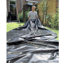 Man legt vijverfolie in de tuin
