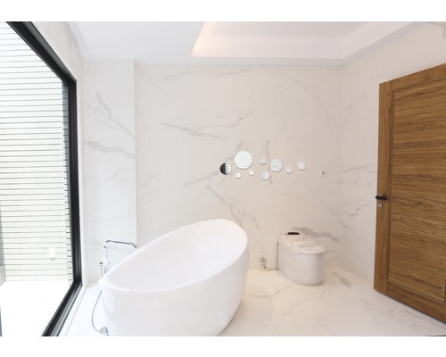 Lichte badkamer met vrijstaand bad, toilet en houten deur