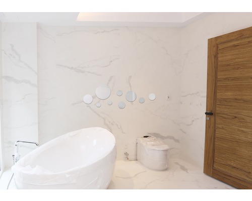 Moderne badkamer met vrijstaand bad, toilet en ronde spiegels als decoratie