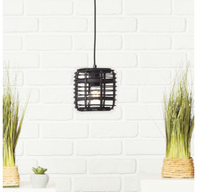 Hanglamp met rotan lampenkap voor een bakstenen muur