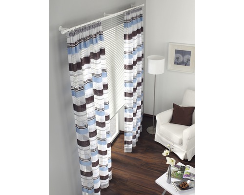 Kamer met gestreepte gordijnen, jaloezieën, fauteuil en vloerlamp