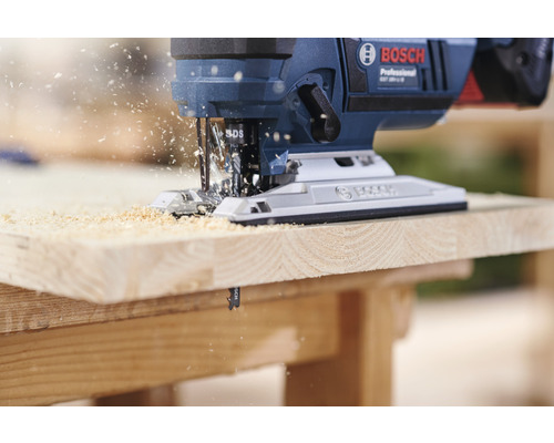 Bosch decoupeerzaag snijdt houten plank met zaagsel