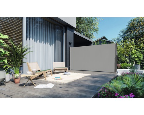 Terras met privacyscherm, tuinmeubilair en planten voor een lichte en georganiseerde buitenruimte.