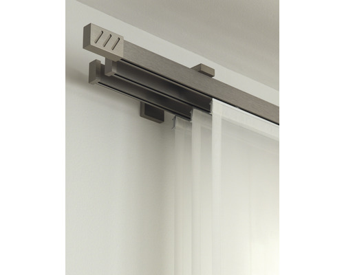 Dubbele gordijnrail met gordijn aan een muur bevestigd