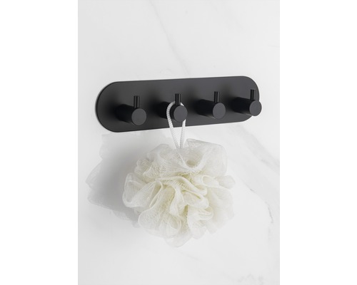 Zwarte wandkapstok met vier haken en een badspons aan een marmeren muur