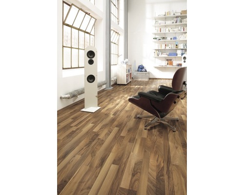 Lichte kamer met laminaatvloer, luidspreker, fauteuil en boekenkast