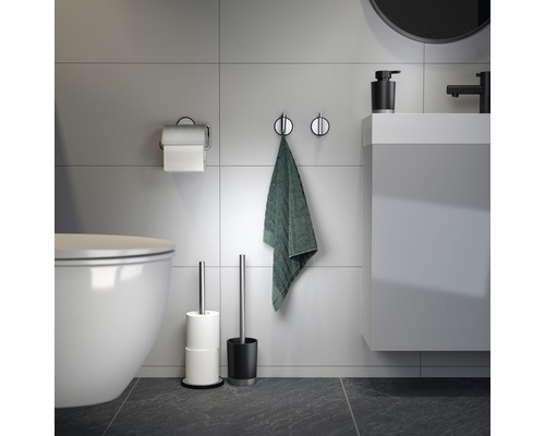 Badkamer met toilet, handdoek, toiletpapierhouder, toiletborstel en wastafel