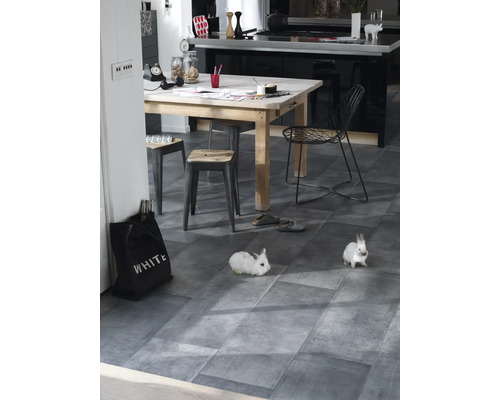 Lichte kamer met eettafel, stoelen, decoratie en twee witte konijnen op een grijze vloer