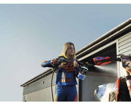 Vrouw reinigt een motorfiets met een hogedrukreiniger.