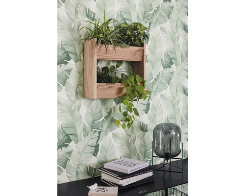 Houten wandrek met planten voor een behang met bladerpatroon