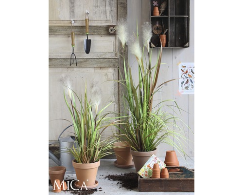 Decoratieve tuinscène met kunstplanten in potten en tuingereedschap