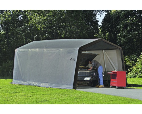 Gemonteerde ShelterLogic opslagtent met een persoon die aan een auto werkt