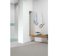 Moderne badkamer met witte tegels, houten bank en handdoeken