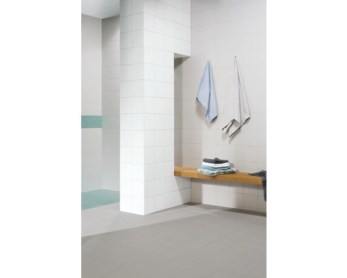 Moderne badkamer met witte tegels, houten bank en handdoeken