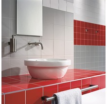 Badkamer met wastafel, spiegel, zeepdispenser en handdoekhouder