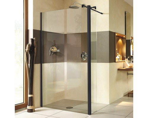 Gelijkvloerse douche met glazen wand en donker frame in een badkamer.