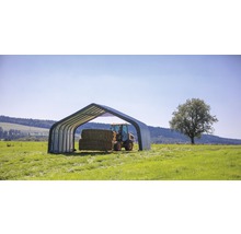 Scene met een schuilplaats voor landbouwmachines en hooibalen in een weide