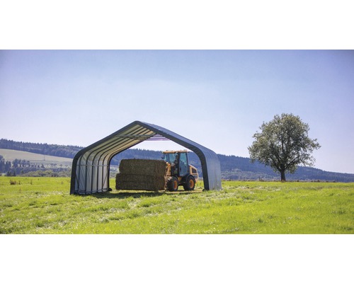 Scene met een schuilplaats voor landbouwmachines en hooibalen in een weide