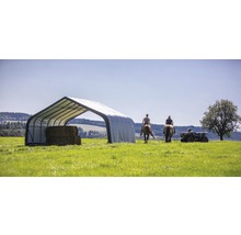 Hooiopslag met hooibalen en personen op paarden en quad