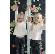 Twee meisjes staan voor een kindermeetlat met vogelmotieven op een donkere muur met bloemmotieven.