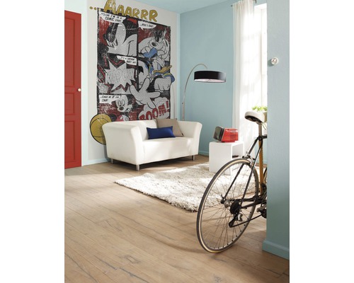 Woonkamer met stripmuurschildering, bank, lamp en fiets