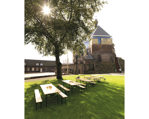 Biertuinscène met houten tafels en banken op een gazon voor een kasteel