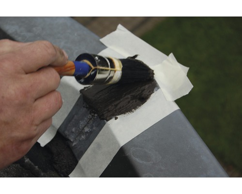 Met een kwast en tape een metalen hek schilderen