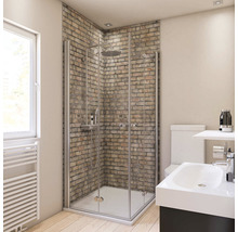 Badkamer met douche, wastafel en toilet tegen een bakstenen muur.