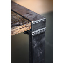Detail van een tafel met houten blad en metalen poten