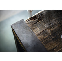Detailopname van een houten tafelblad met metalen rand