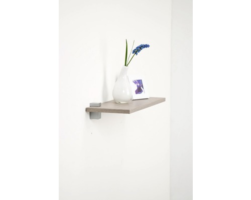 Wandplank met vaas en fotolijst aan de muur