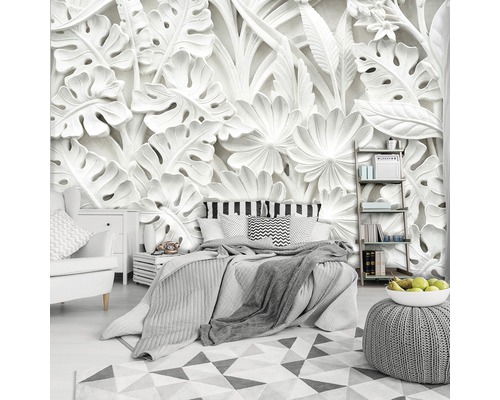 Slaapkamer met bed, nachtkastje, fauteuil en wandbehang met bloemmotief