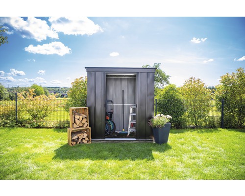 Tuinhuis met tuingereedschap en hout in de tuin