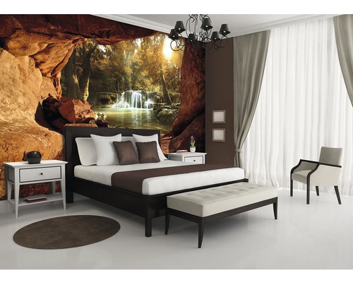 Slaapkamer met fotobehang dat een rotsformatie en een waterval voorstelt, bed, nachtkastje, vloerkleed en bank