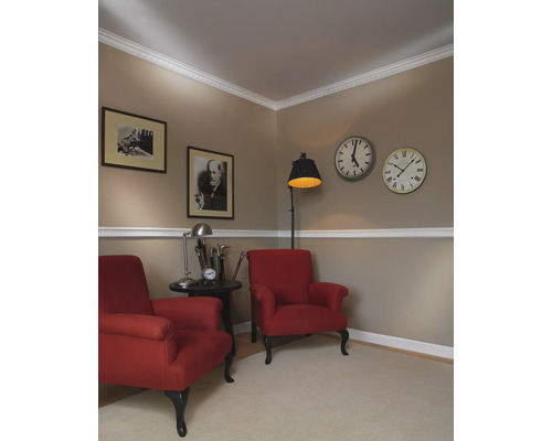 Klassiek ingerichte woonkamer met twee rode fauteuils, schilderijen en klokken aan de muur